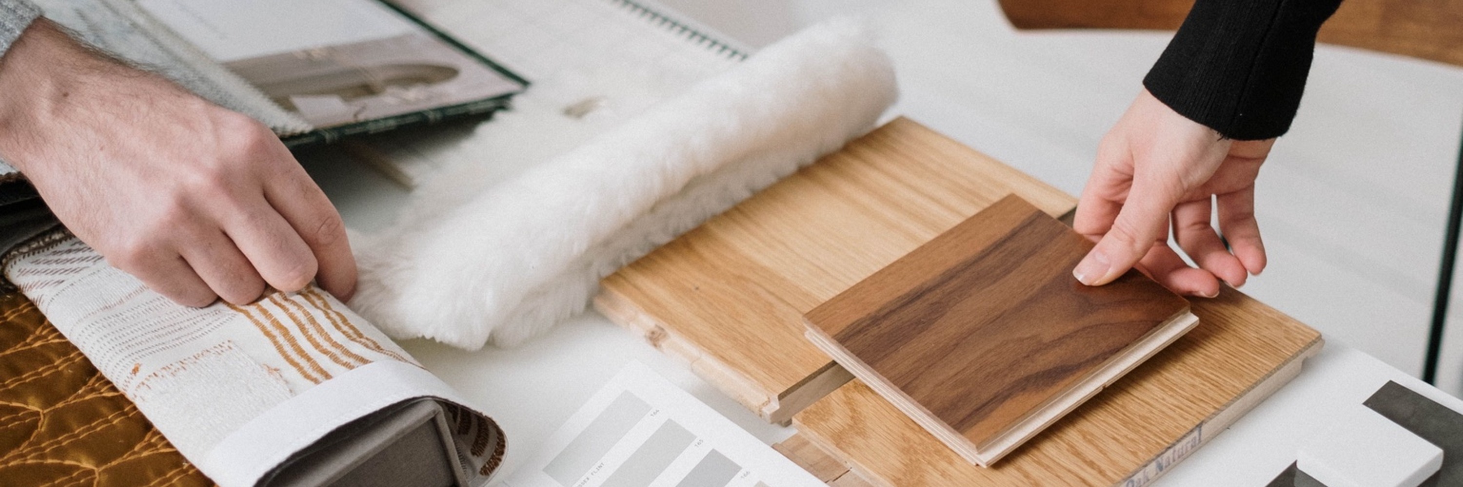 Designer and customer reviewing wood flooring samples