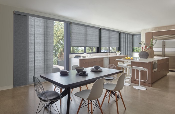     Modern kitchen and dining space with custom roller shades, cabinetry, and flooring